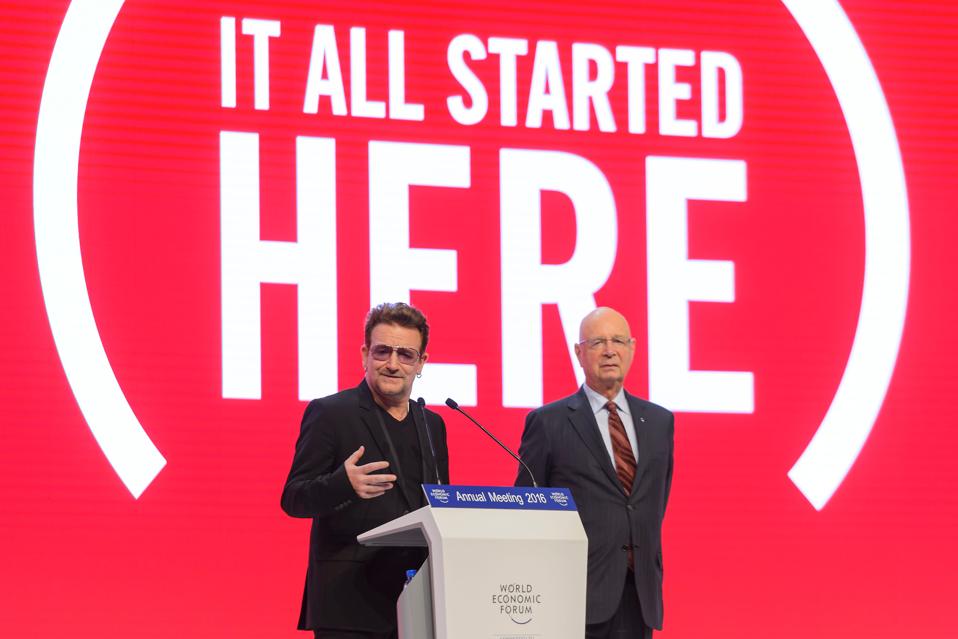 Bono Vox, musido da banda U2, addresses the assembly, flanked by World Economic Forum (WEF)